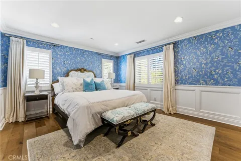 a spacious bedroom with a bed and wooden floor