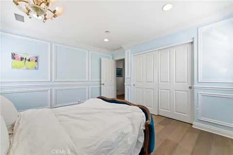 a bedroom with a large bed and a chandelier