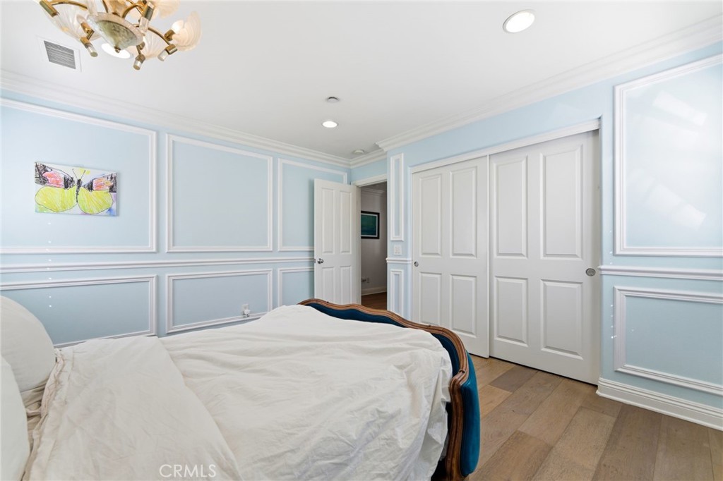 27 Gardenpath Irvine, CA 92603 - Photo 24 of 34 a bedroom with a large bed and a chandelier