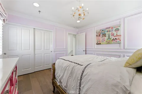 a spacious bedroom with a bed and a chandelier