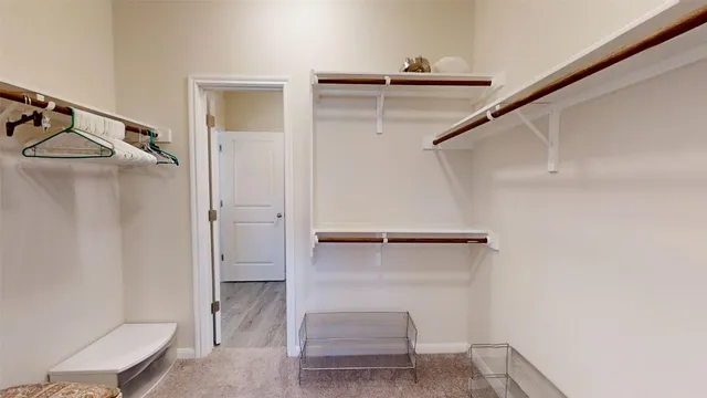 a view of walk in closet with empty racks