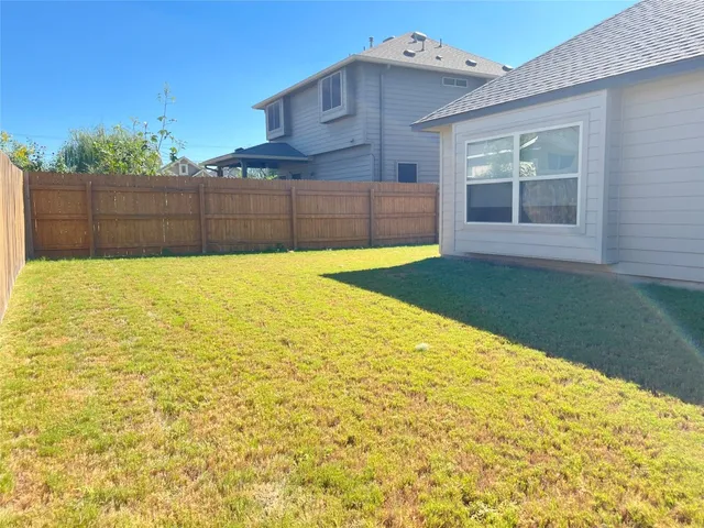 a view of a backyard with wooden fence