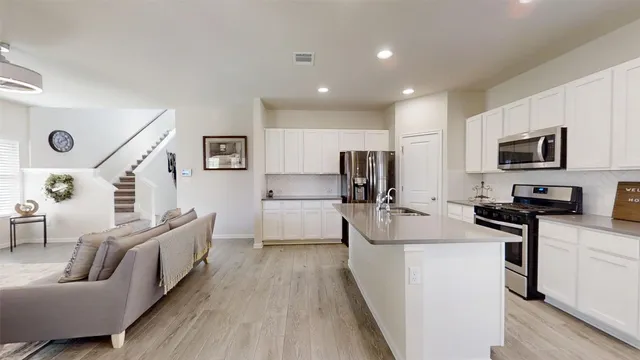 a kitchen with white cabinets and stainless steel appliances