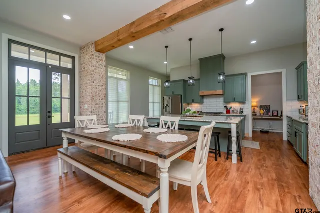 a kitchen with stainless steel appliances granite countertop a kitchen island a stove a table and chairs