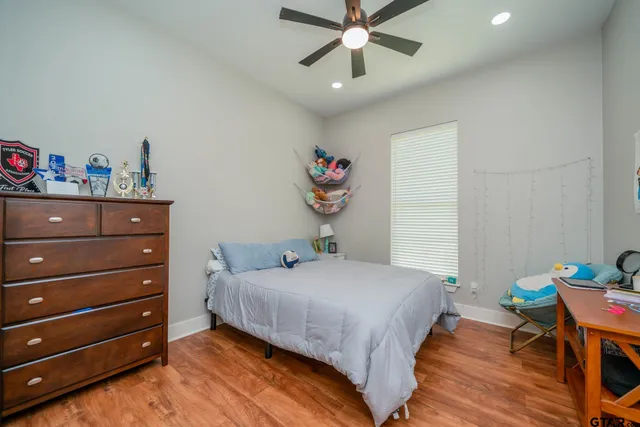 a bedroom with a bed and a wooden floor