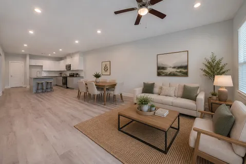 a living room with furniture and a dining table with wooden floor