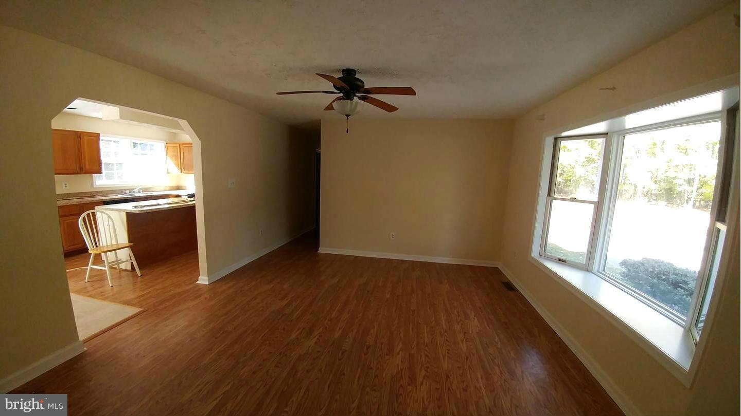 7435 Simms Landing Road Port Tobacco, MD 20677 - Photo 6 of 26 a view of an empty room with a window and wooden floor