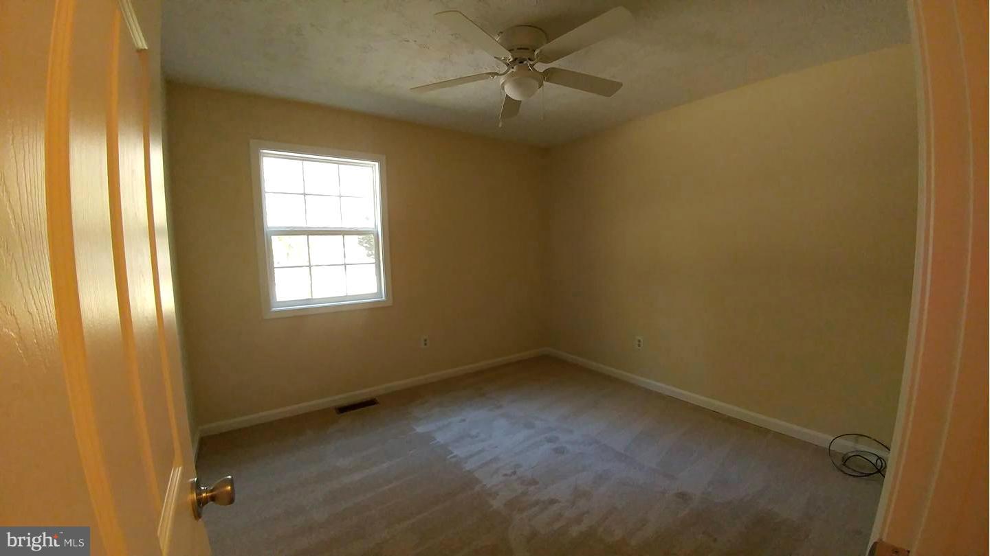 7435 Simms Landing Road Port Tobacco, MD 20677 - Photo 9 of 26 an empty room with windows and fan