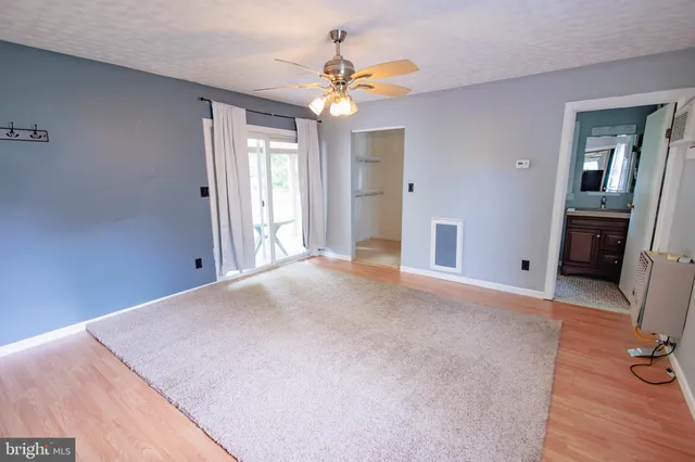 a view of a livingroom with a ceiling fan and hardwood floor