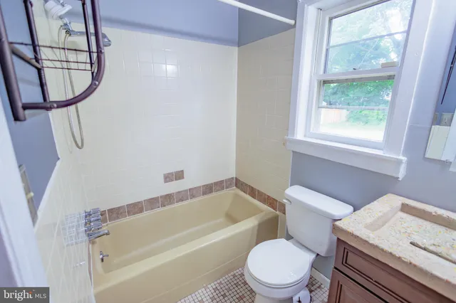a white toilet sitting next to a bath tub