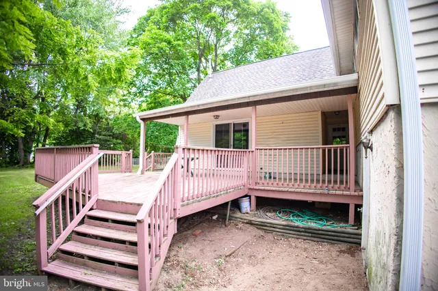 a view of a house with wooden deck and wooden fence