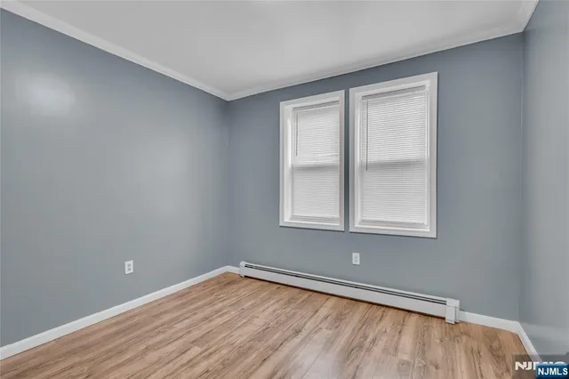 a view of a hallway with wooden floor and closet area