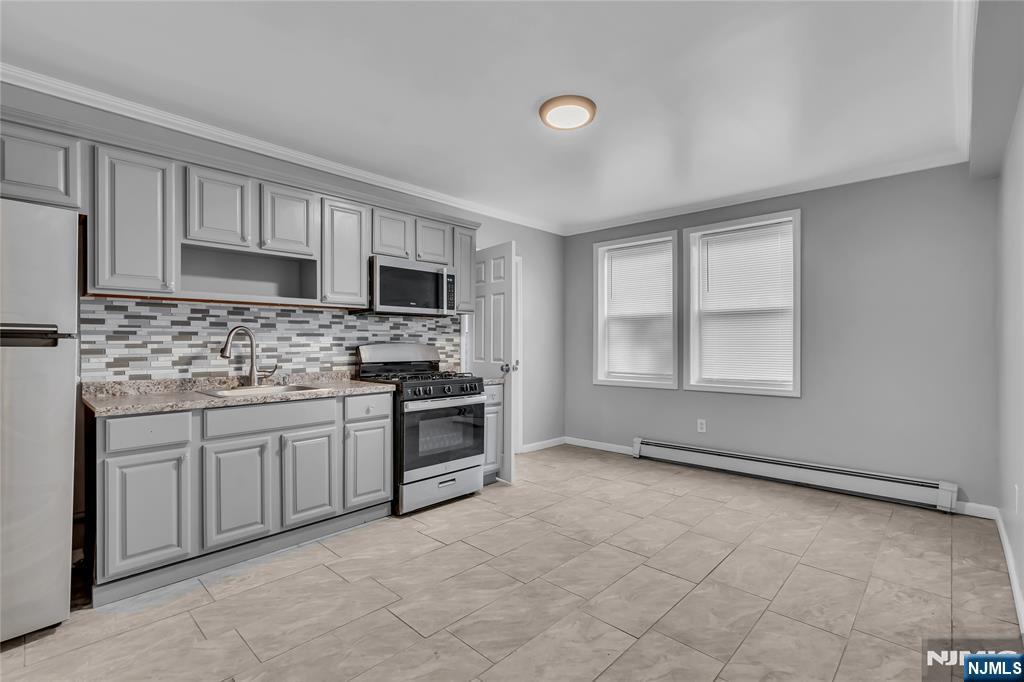 537 Scotland Road, Unit 2 Orange, NJ 07050 - Photo 2 of 17 a kitchen with granite countertop a stove sink and microwave