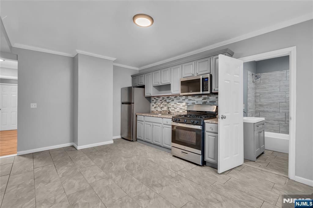 537 Scotland Road, Unit 2 Orange, NJ 07050 - Photo 3 of 17 a kitchen with stainless steel appliances granite countertop a stove top oven a sink and a refrigerator
