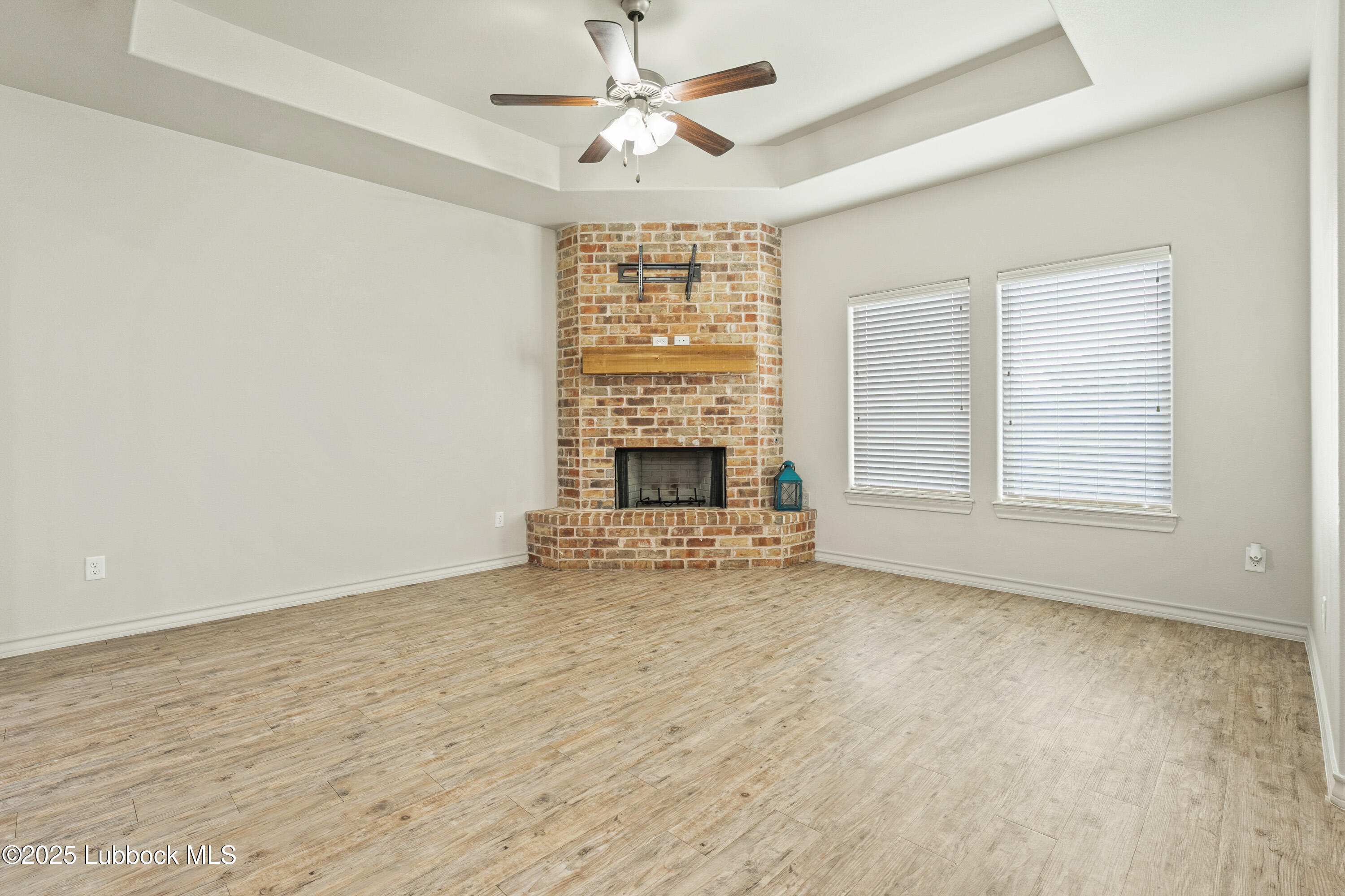 5303 Lehigh Street Lubbock, TX 79416 - Photo 11 of 31 an empty room with fireplace and windows