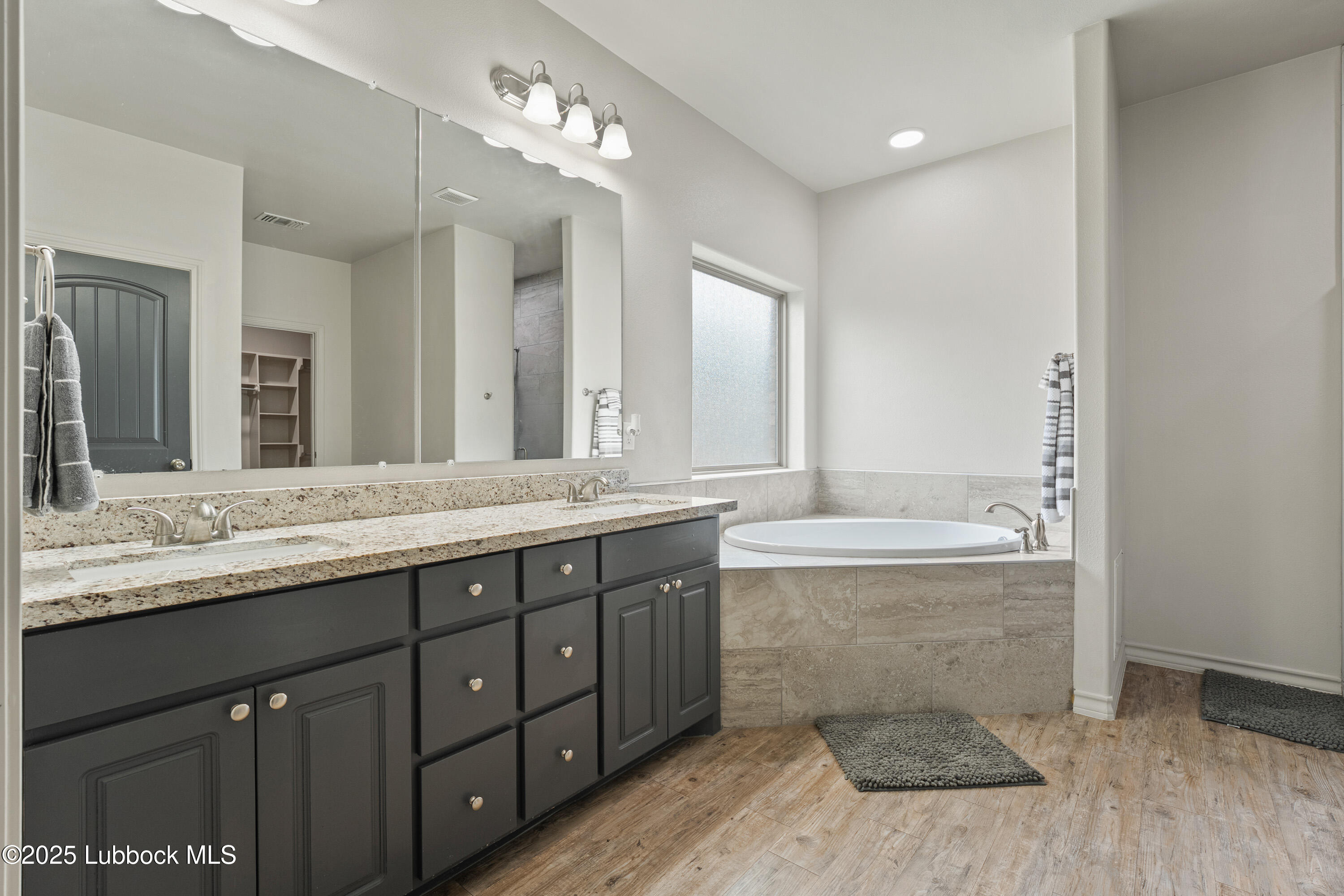 5303 Lehigh Street Lubbock, TX 79416 - Photo 17 of 31 a bathroom with a granite countertop bathtub sink double and mirror