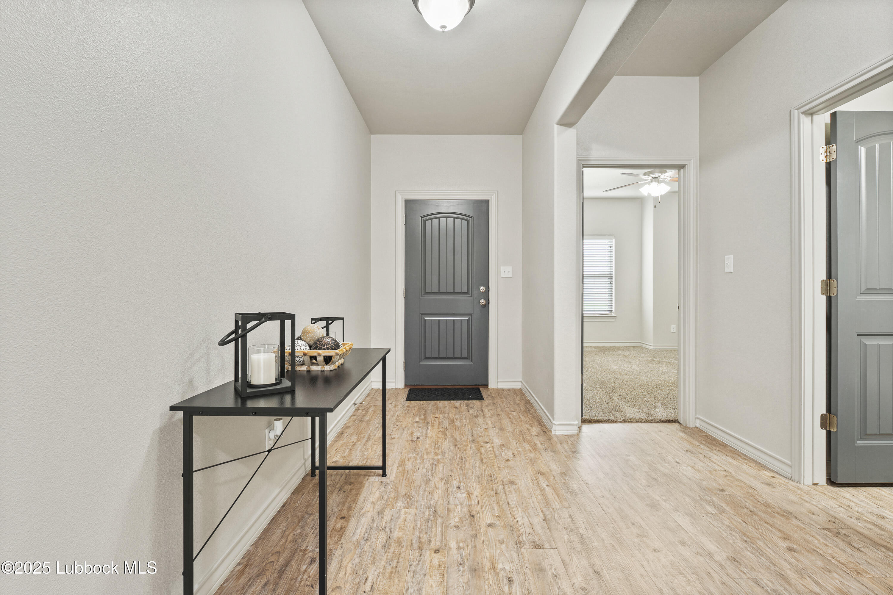 5303 Lehigh Street Lubbock, TX 79416 - Photo 4 of 31 a view of a hallway to a livingroom with wooden floor and furniture