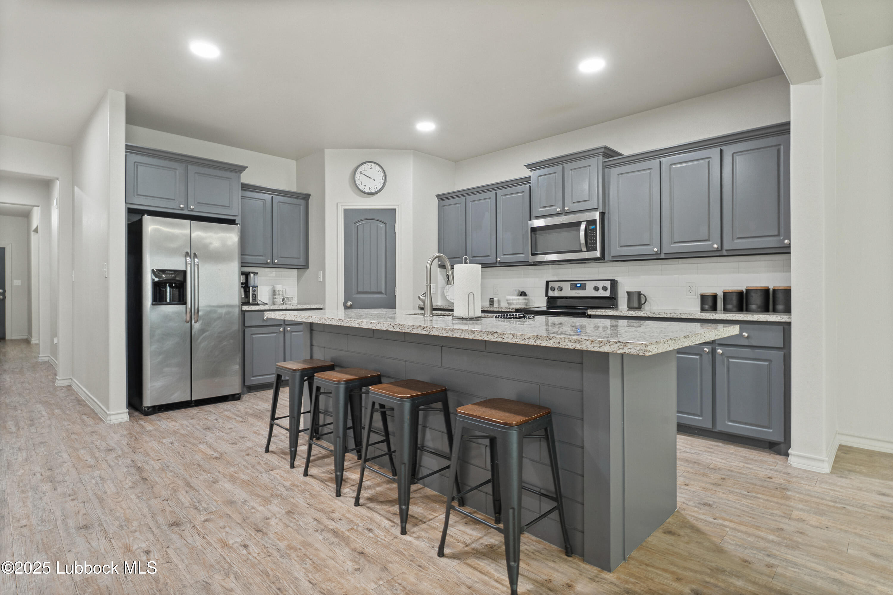 5303 Lehigh Street Lubbock, TX 79416 - Photo 6 of 31 a kitchen with granite countertop a table chairs microwave and refrigerator
