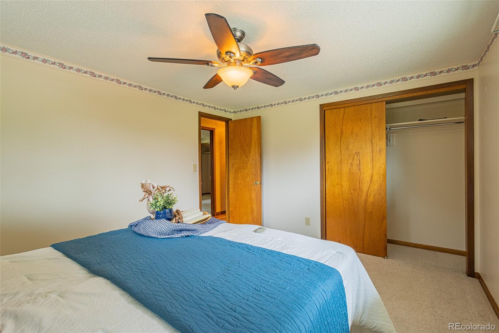98 Button Rock Road Lyons, CO 80540 - Photo 13 of 40 a bedroom that has a bed and a chandelier fan