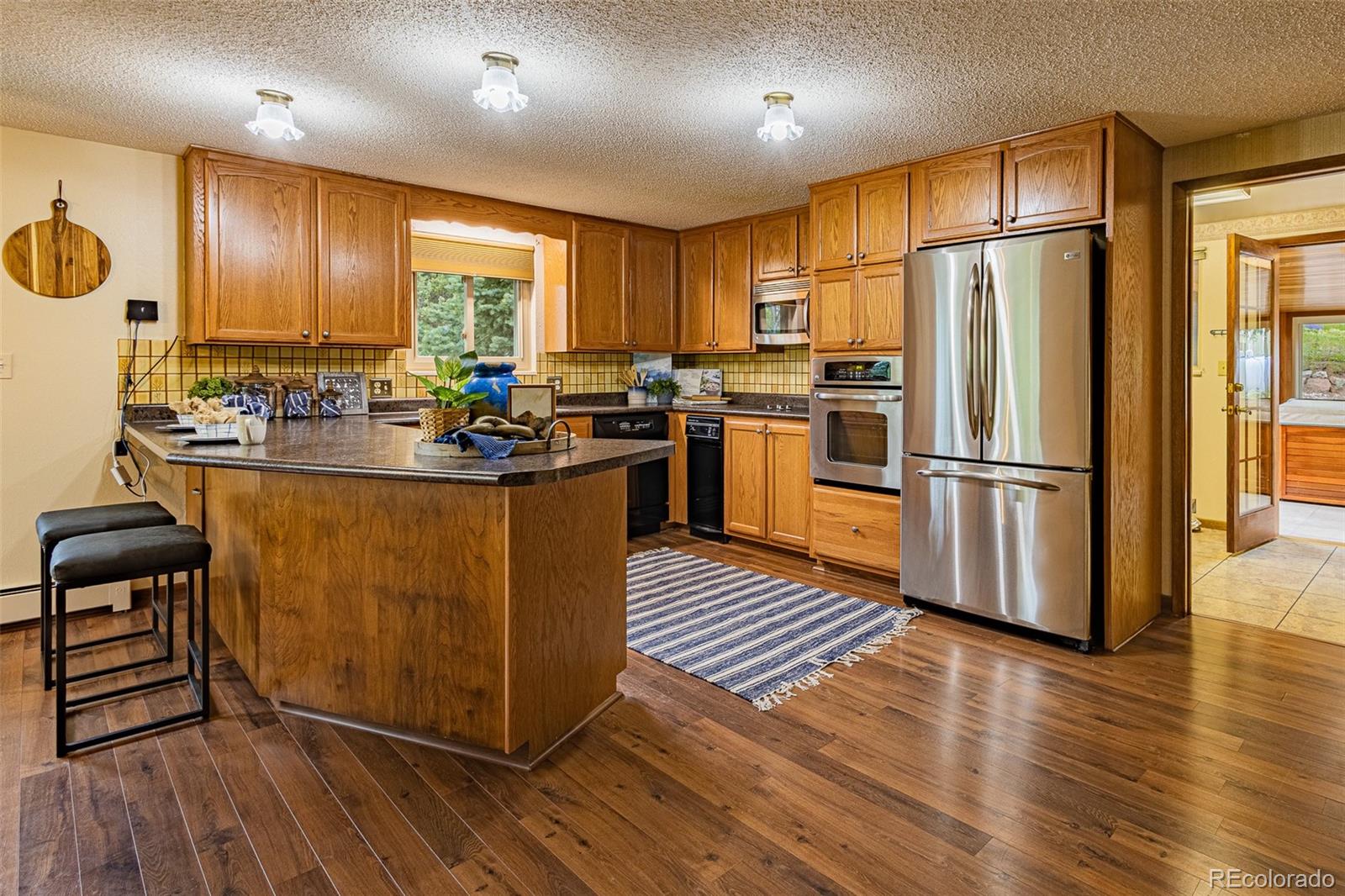 98 Button Rock Road Lyons, CO 80540 - Photo 5 of 40 a kitchen with stainless steel appliances granite countertop a refrigerator a stove and a wooden floors