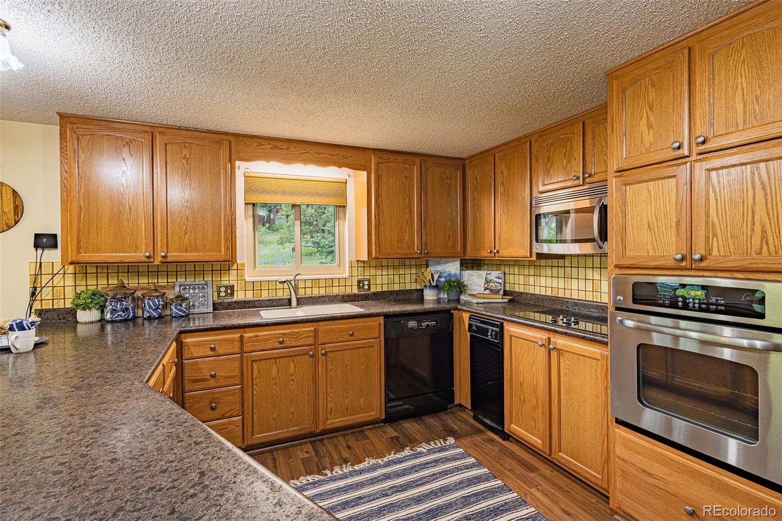 98 Button Rock Road Lyons, CO 80540 - Photo 7 of 40 a kitchen with stainless steel appliances granite countertop a stove a sink dishwasher and a refrigerator