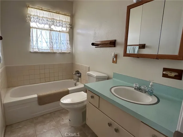 a bathroom with a sink toilet a tub and vanity
