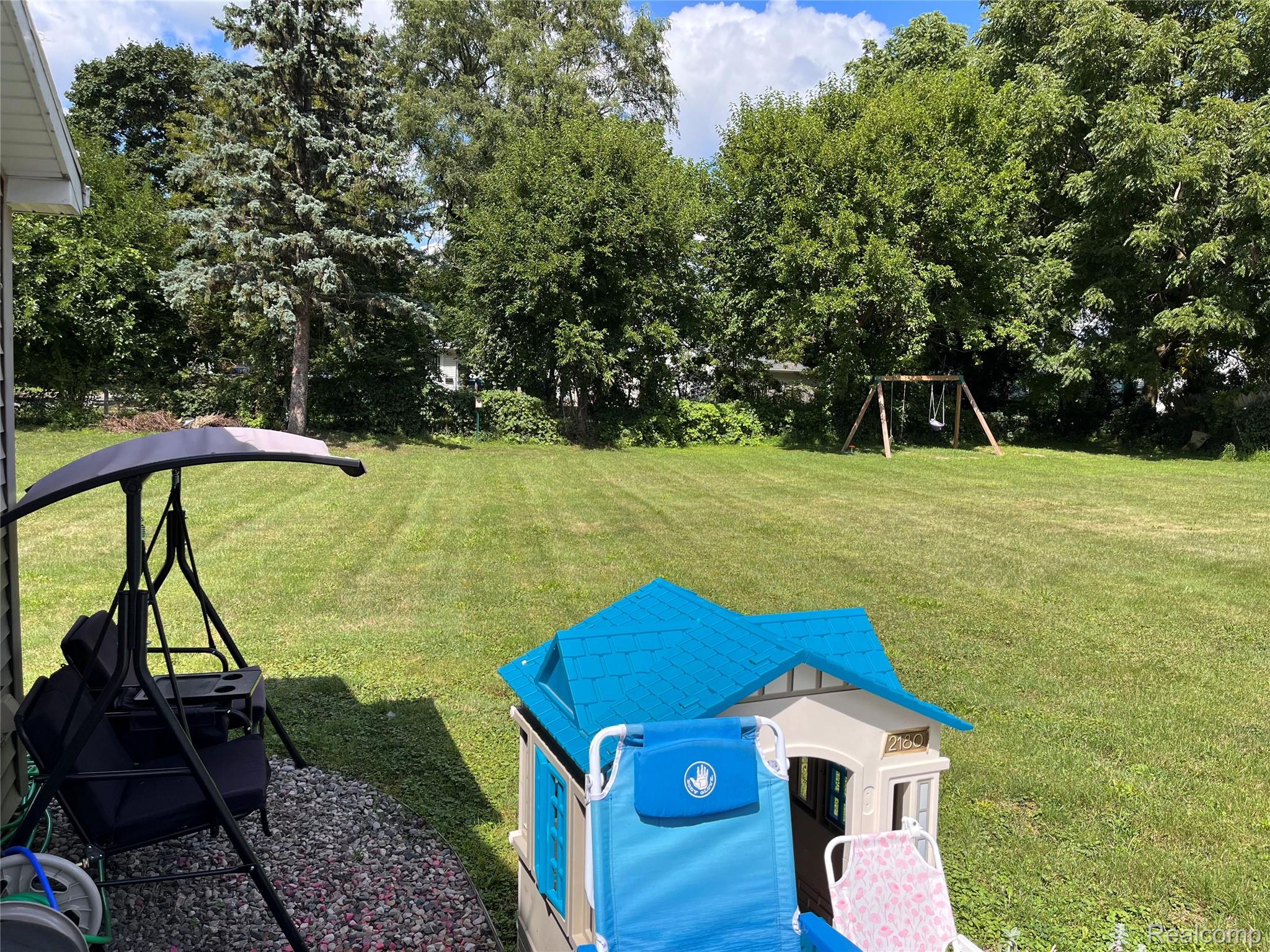 2308 Rheamount Avenue Lansing, MI 48906 - Photo 10 of 10 Spacious backyard with mature trees, expansive lawn, and partial patio area