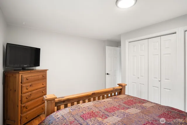 a bedroom with a bed and flat screen tv