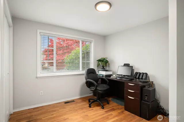 a view of a workspace with furniture and a window