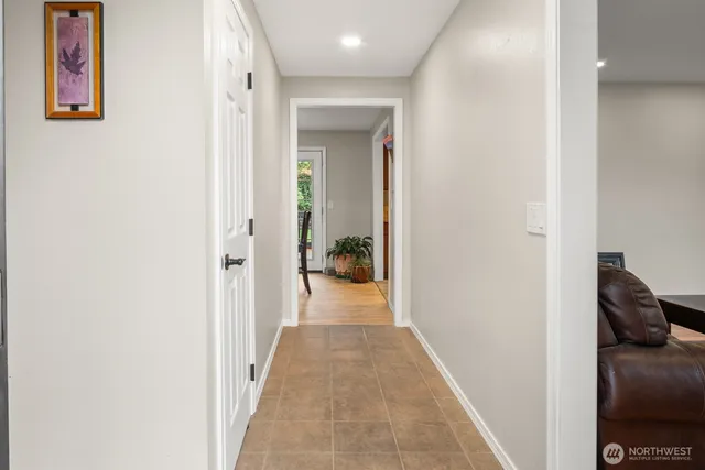 a view of a hallway with wooden floor and closet