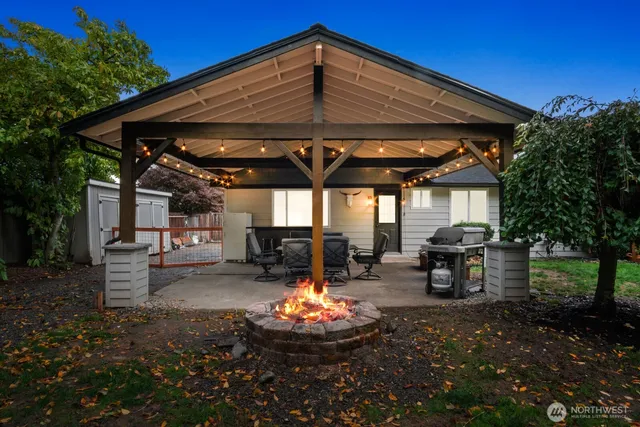 a view of a backyard with table and chairs under an umbrella