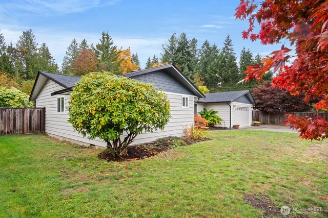 a view of a house with a yard and tree s