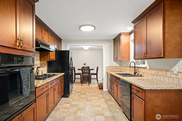 a kitchen with stainless steel appliances granite countertop a sink stove and cabinets