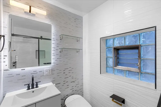 a bathroom with a toilet a sink and mirror