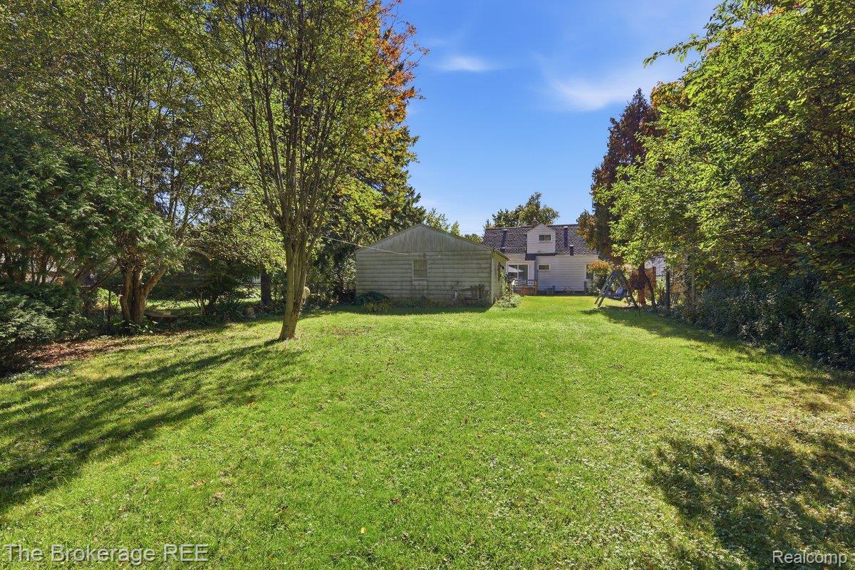 613 East Atherton Road Flint, MI 48507 - Photo 33 of 42 Expansive grassy yard with mature trees and a detached shed