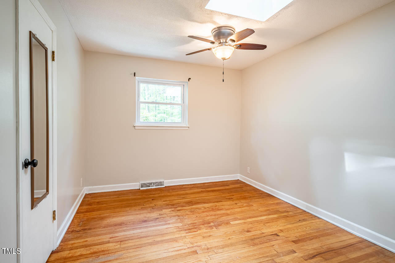 210 Landsbury Drive Durham, NC 27707 - Photo 15 of 20 an empty room with a chandelier fan and windows