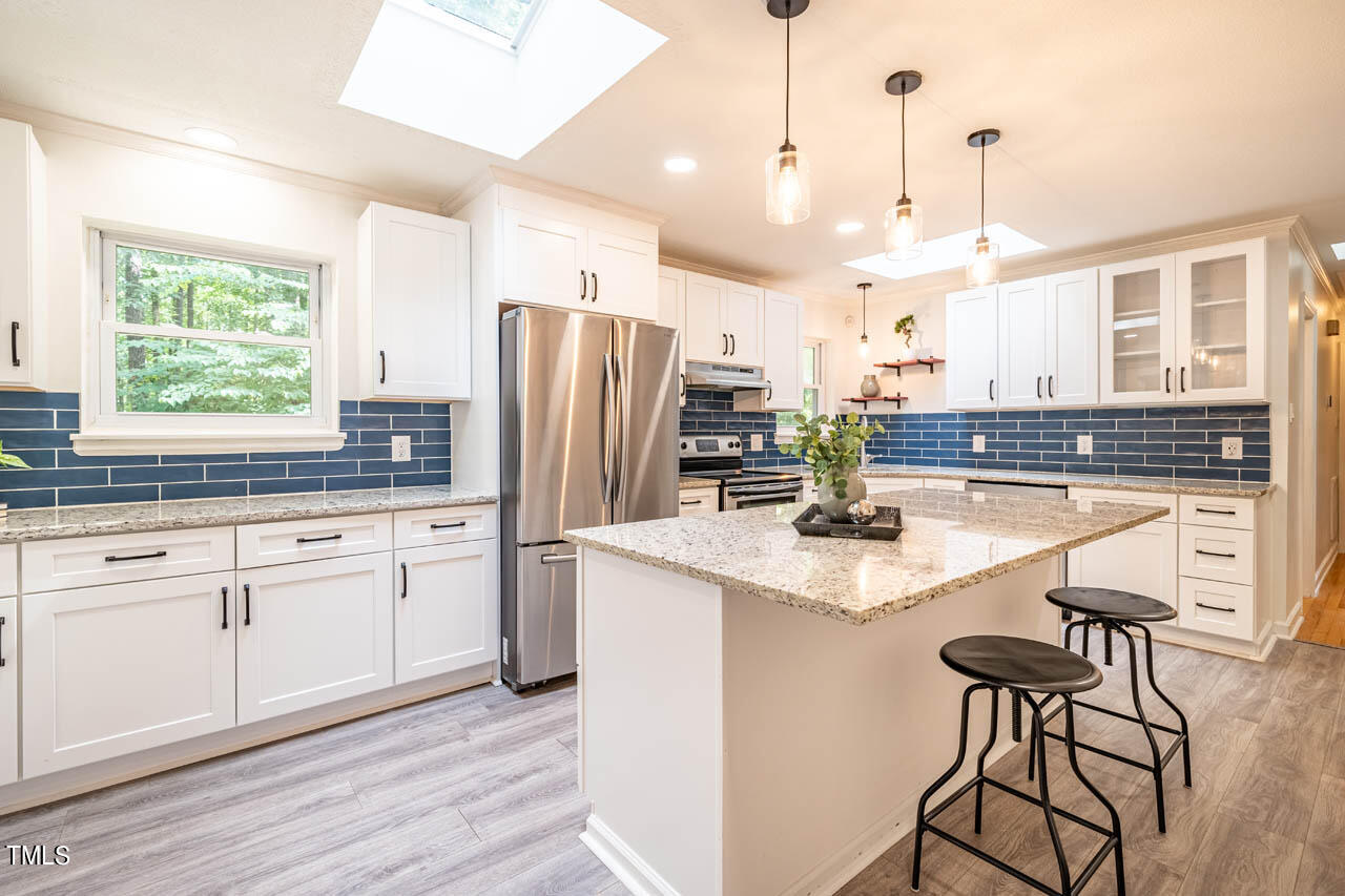 210 Landsbury Drive Durham, NC 27707 - Photo 5 of 20 a kitchen with stainless steel appliances granite countertop a sink a stove and a refrigerator