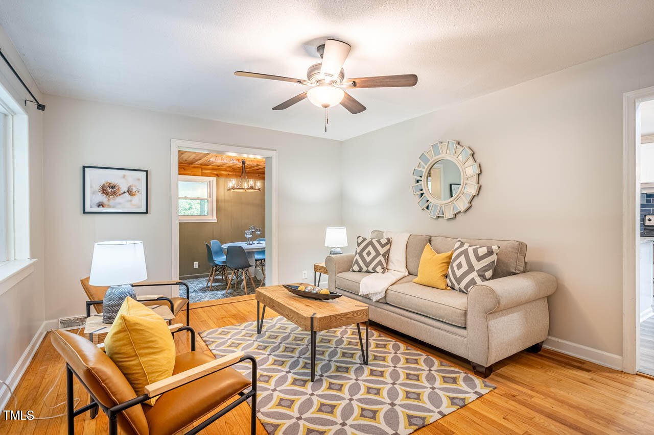 210 Landsbury Drive Durham, NC 27707 - Photo 9 of 20 a living room with furniture and a chandelier