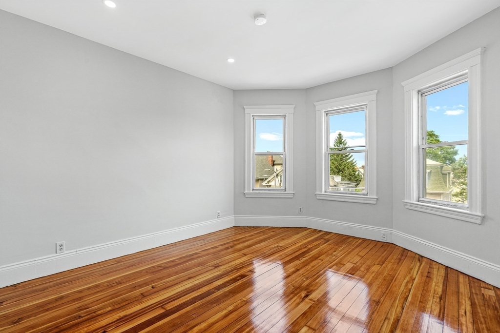 79 Pleasant Street Boston, MA 02125 - Photo 14 of 34 an empty room with wooden floor and windows