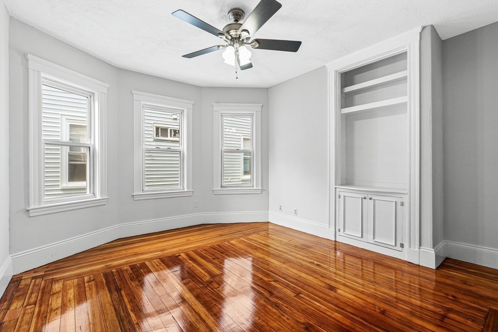 79 Pleasant Street Boston, MA 02125 - Photo 19 of 34 a view of an empty room with window and wooden floor