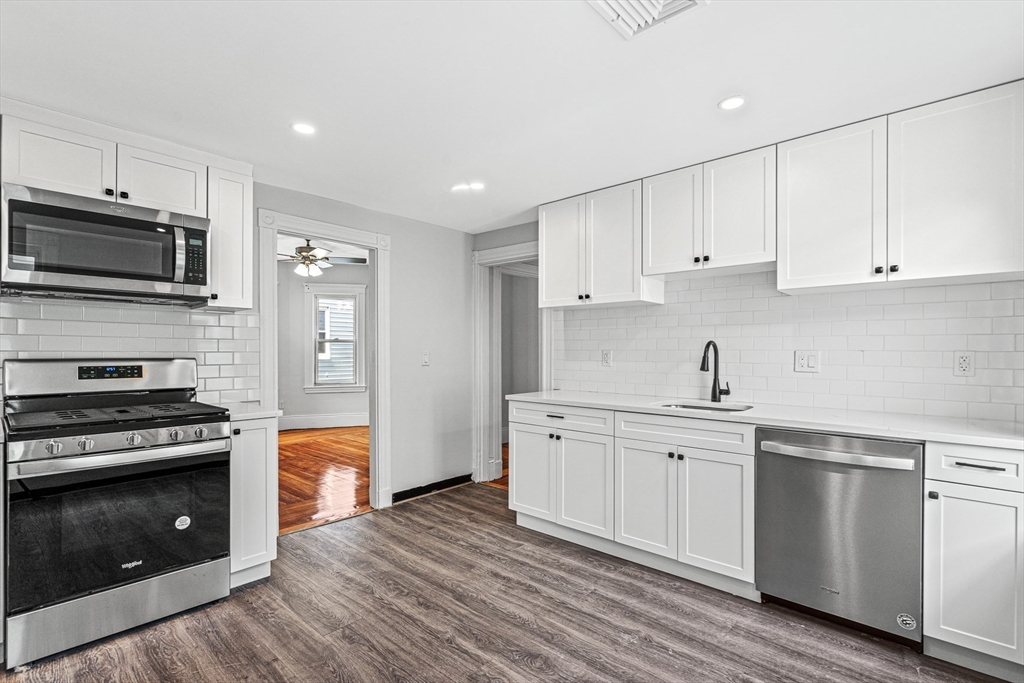 79 Pleasant Street Boston, MA 02125 - Photo 2 of 34 a kitchen with stainless steel appliances granite countertop a stove top oven a sink and cabinets