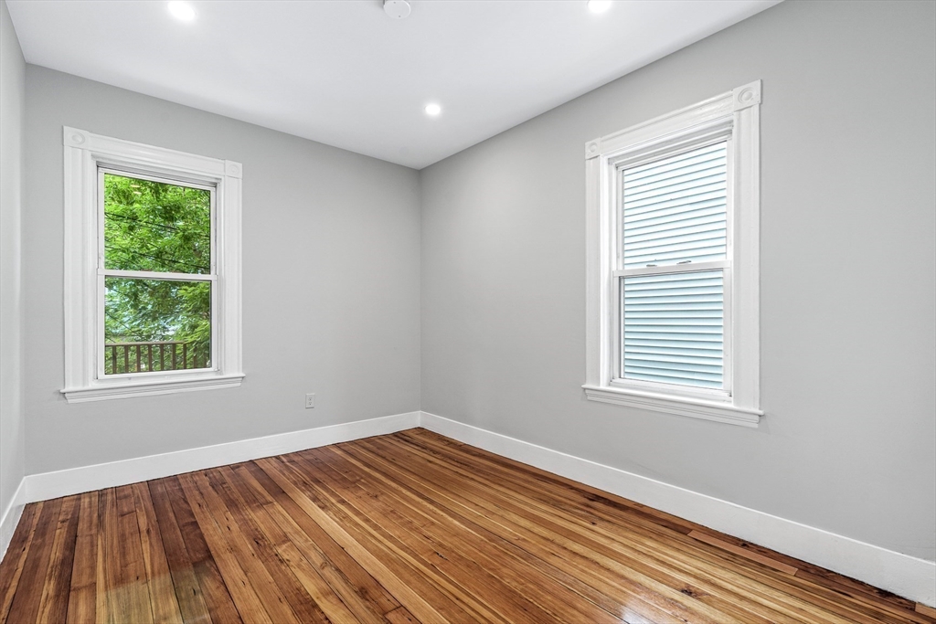 79 Pleasant Street Boston, MA 02125 - Photo 27 of 34 an empty room with wooden floor and windows