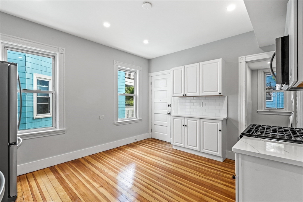 79 Pleasant Street Boston, MA 02125 - Photo 28 of 34 a kitchen with white cabinets and wooden floor
