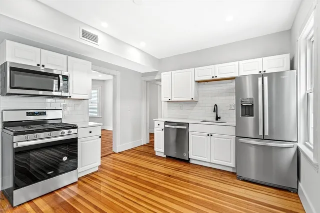 a kitchen with granite countertop a refrigerator stove and microwave