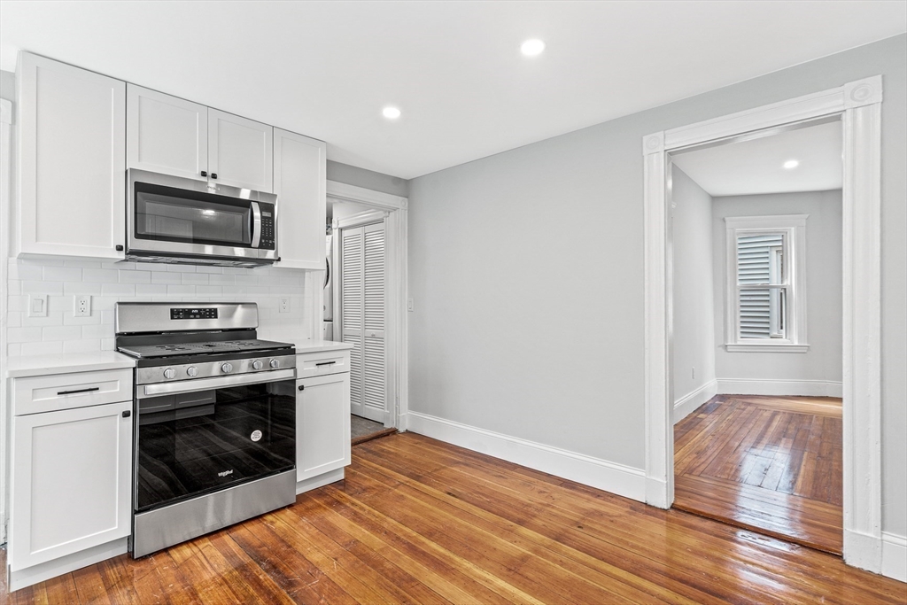 79 Pleasant Street Boston, MA 02125 - Photo 9 of 34 a kitchen with stainless steel appliances a stove a microwave and sink