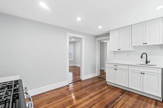 a view of a kitchen with sink and dishwasher with wooden floor