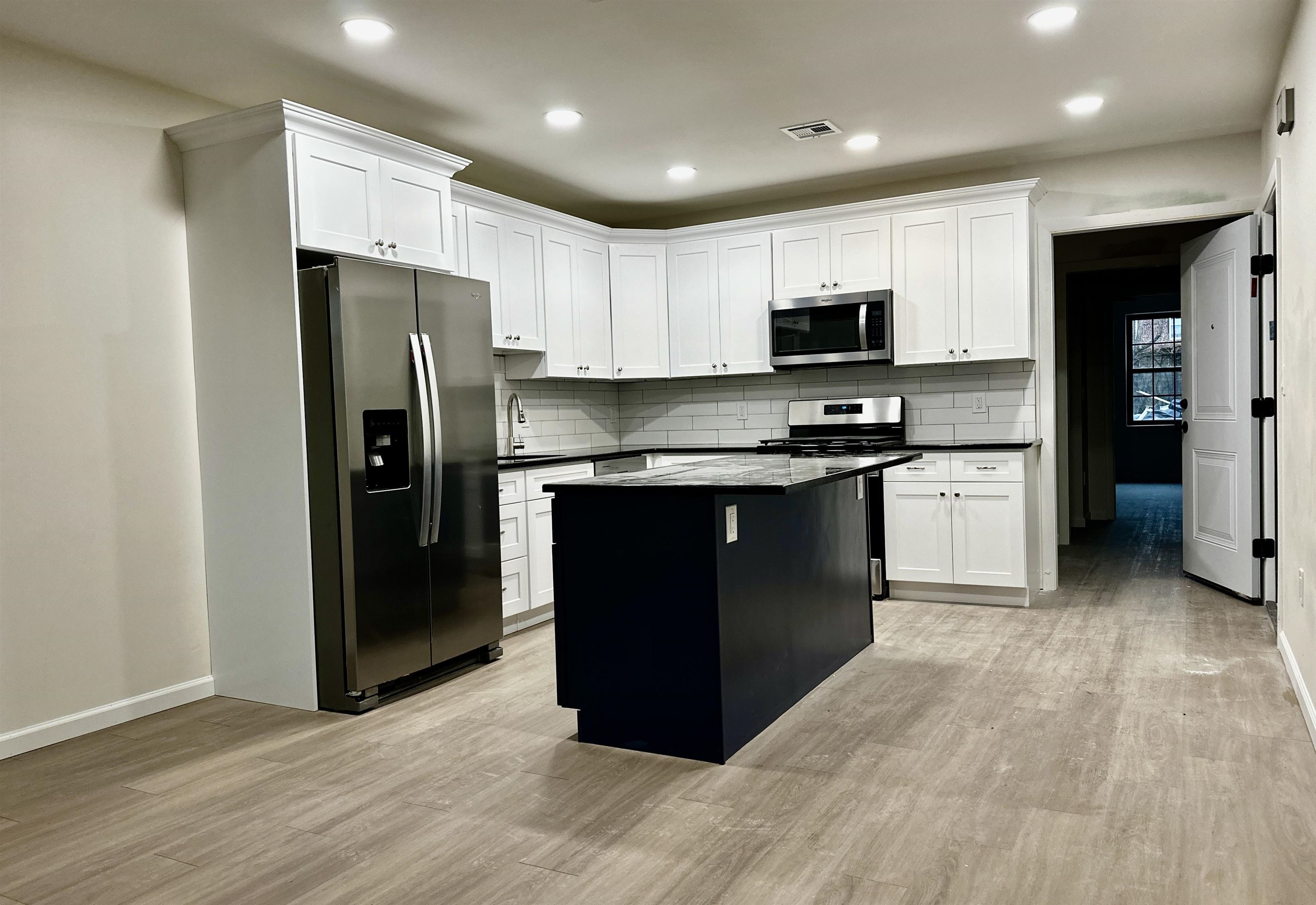 a kitchen with stainless steel appliances granite countertop a refrigerator and a stove top oven