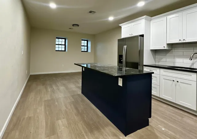 a kitchen with kitchen island granite countertop stainless steel appliances a sink stove and refrigerator
