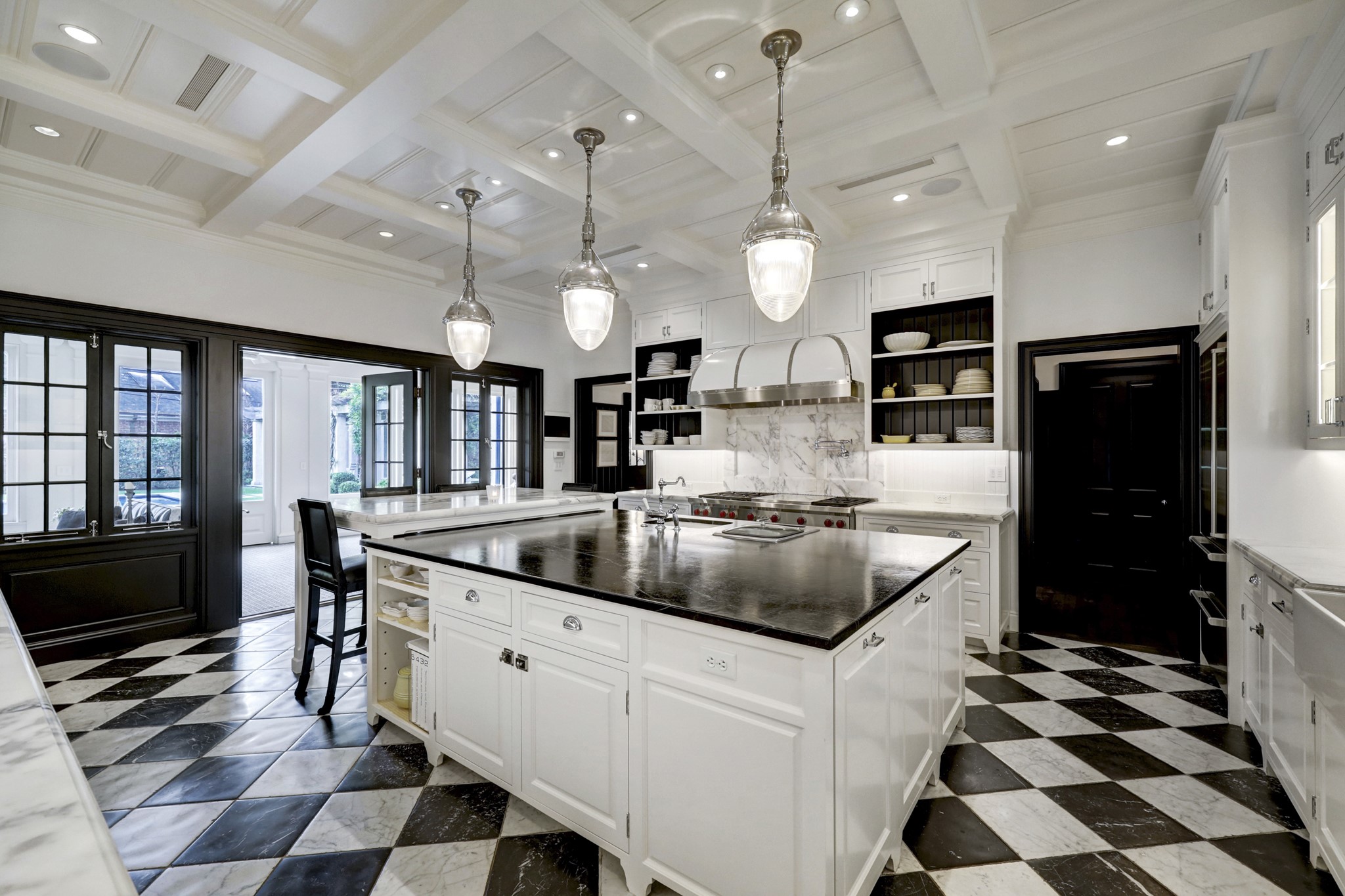 3 Briarwood Court Houston, TX 77019 - Photo 11 of 50 The Island Kitchen with imported French marble, checkered tile floors. Soapstone counter with marble breakfast bar seating. Stainless high-end appliances. Additional vegetable sink and steamer at island. The kitchen opens to the screened porch. Doorway on right side of photo leads to walk-in pantry and door to screened-in outdoor kitchen with stainless Texas Pit Crafters Gas Grill.