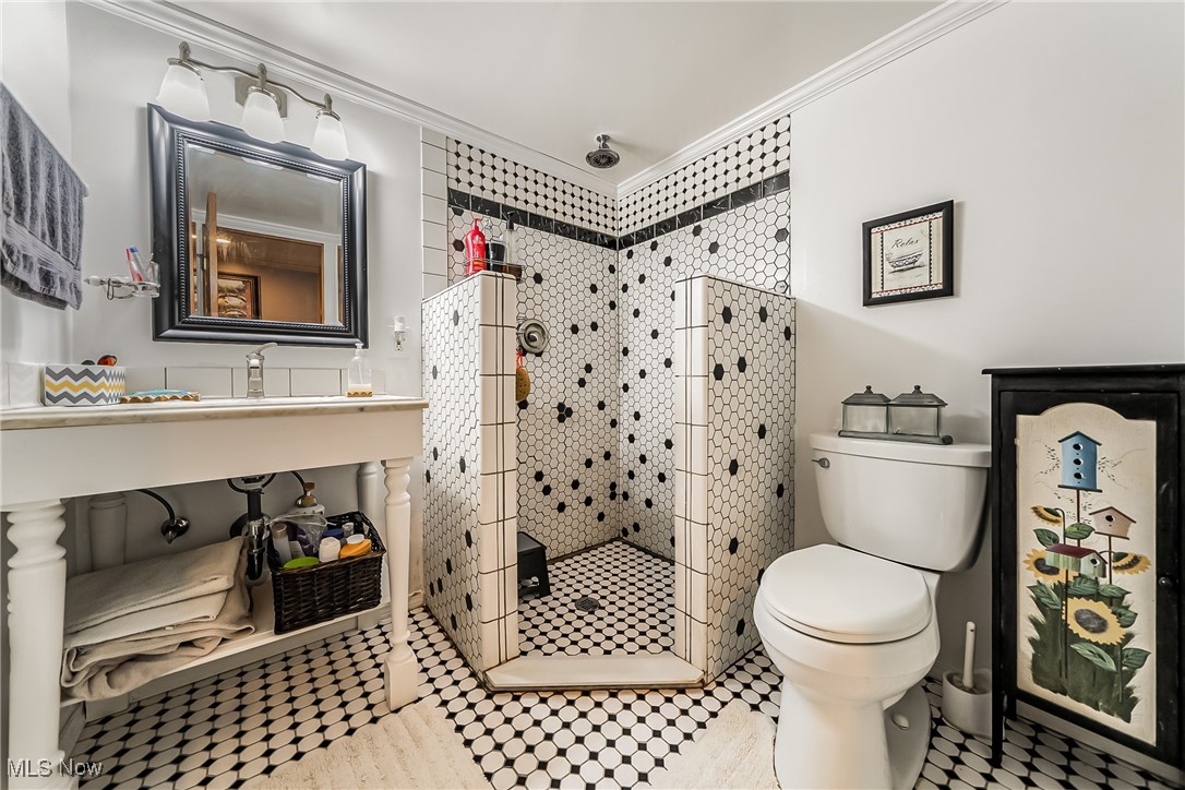 6287 Highland Road Cleveland, OH 44143 - Photo 28 of 46 Bathroom featuring tile patterned floors, toilet, a tile shower, and crown molding